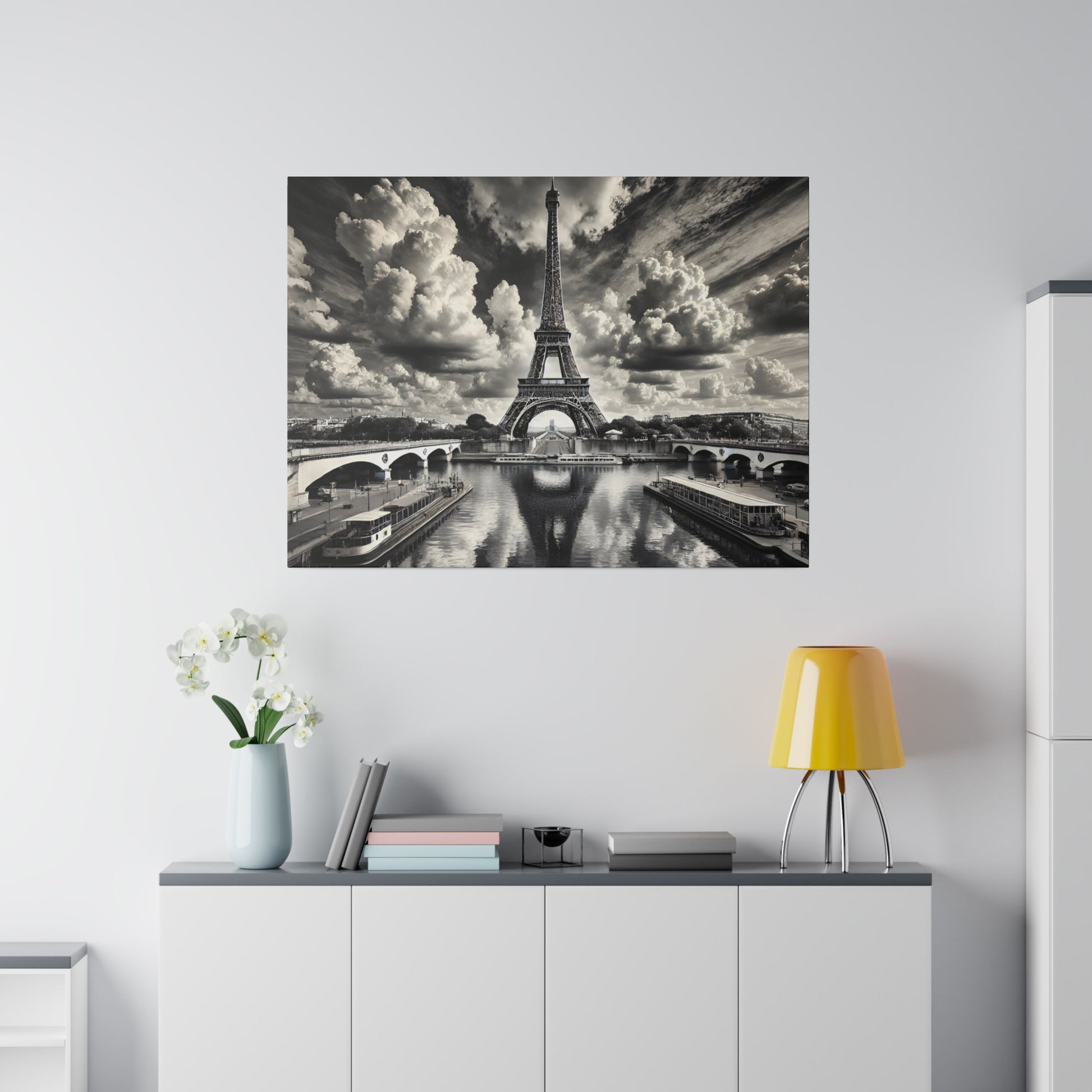 Black-and-white wall art showing the Eiffel Tower over the Seine with bridges, boats, and dramatic clouds.