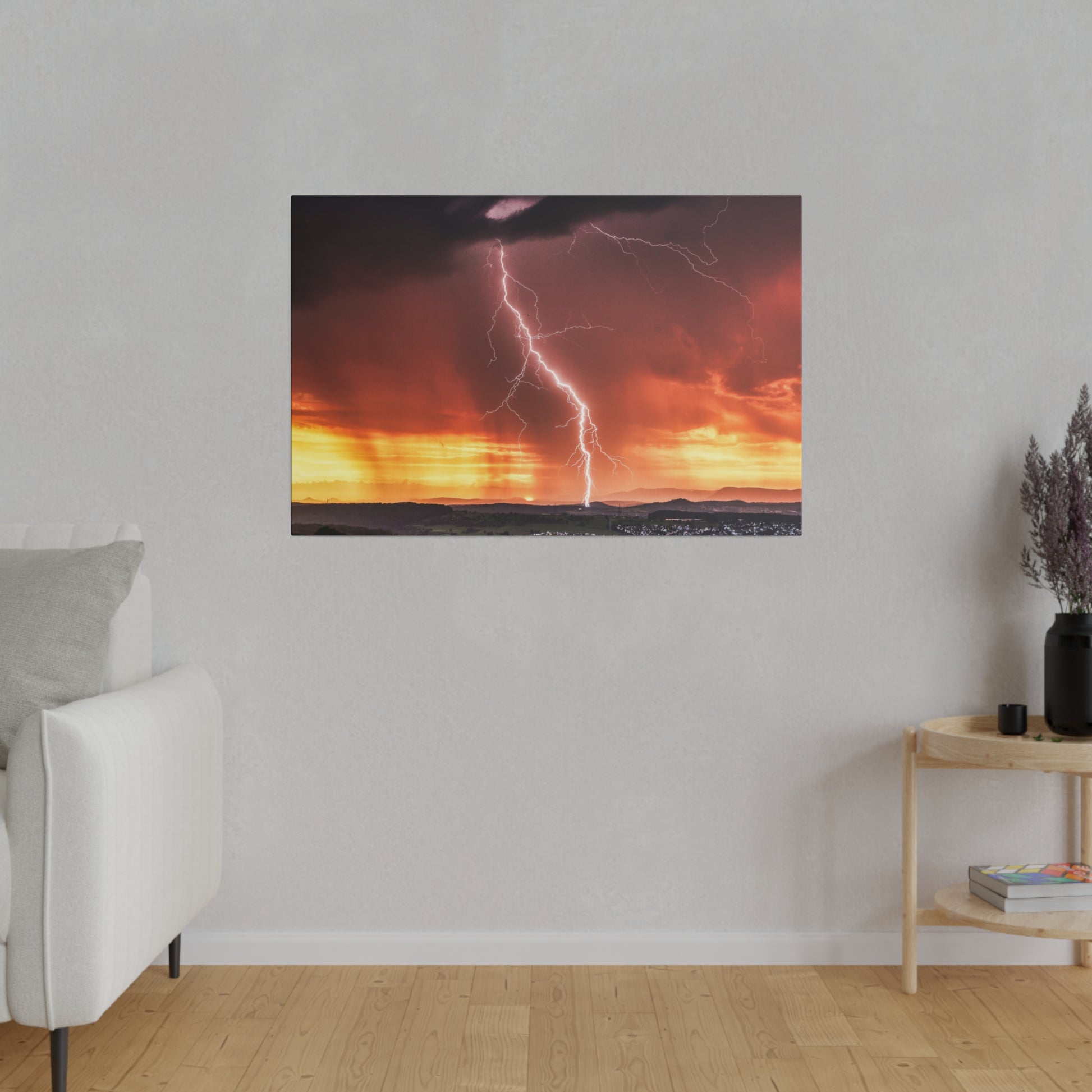 Framed photo of a bright lightning bolt across an orange sunset over a distant horizon, hung on a gray living-room wall.