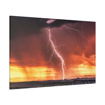 Bright white lightning bolt streaks from dark storm clouds to the orange sunset, over a hilly landscape.