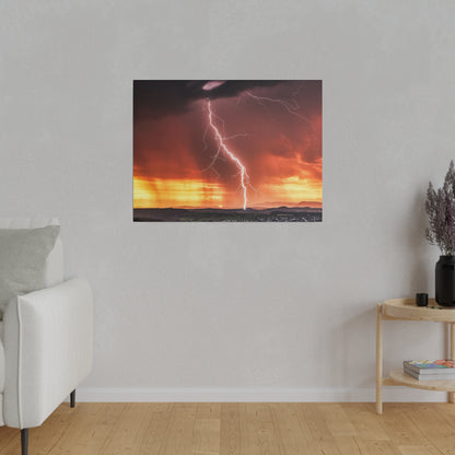 Framed wall art showing a lightning bolt over a horizon at sunset with orange and purple skies.