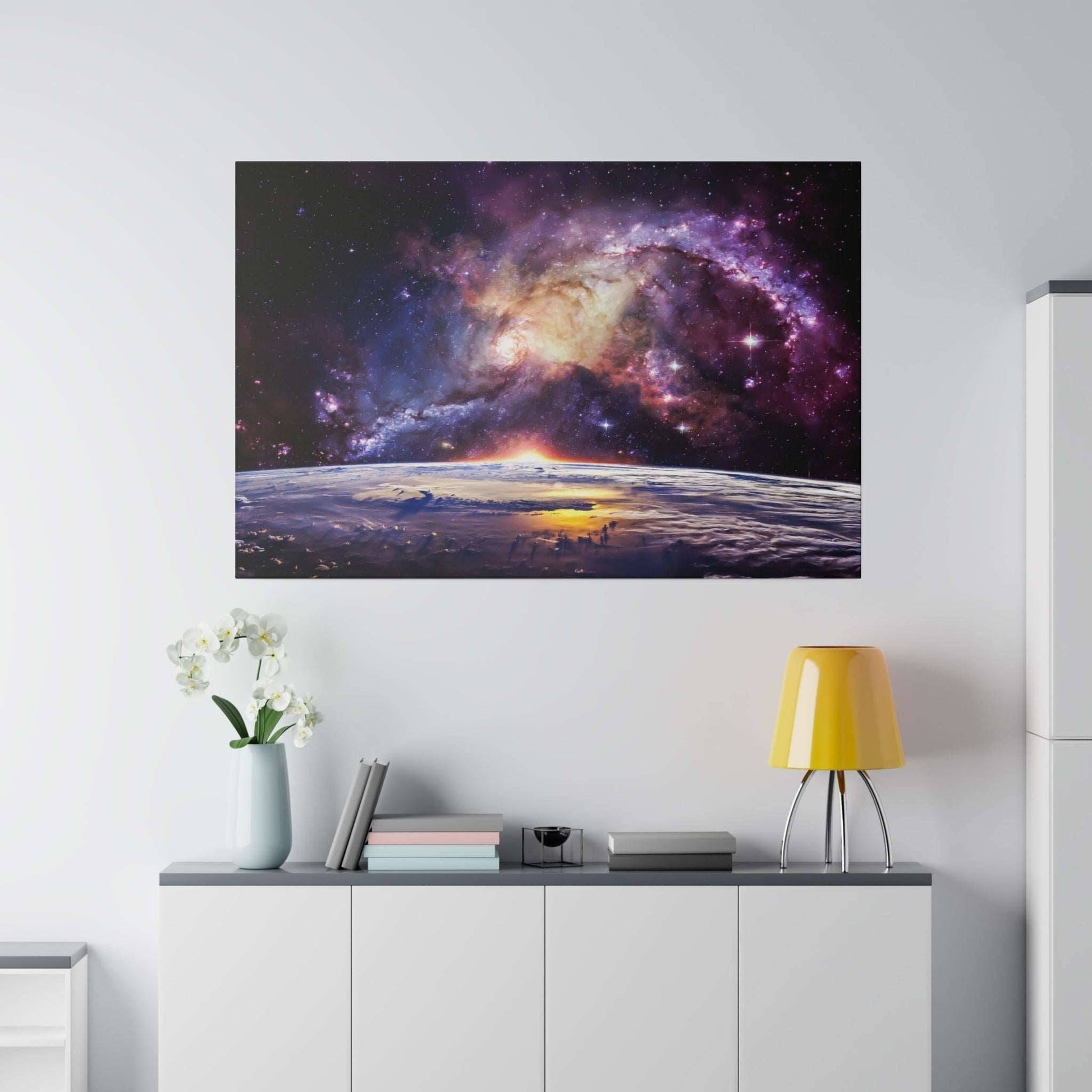 Canvas art depicting a colorful galaxy over Earth's horizon at sunrise, mounted on a white wall.