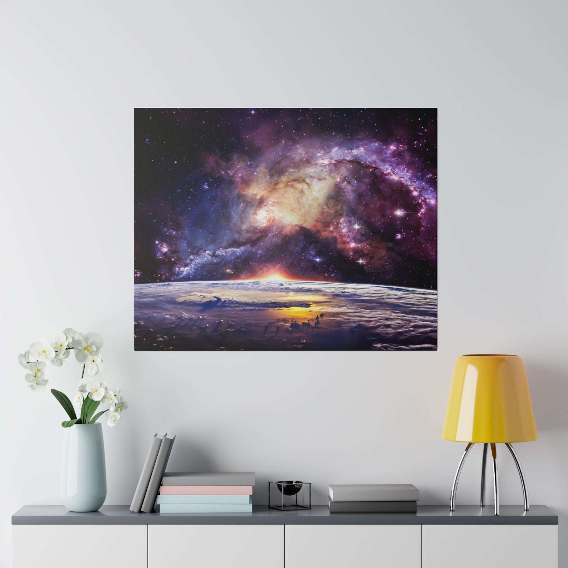 Canvas art depicting a colorful spiral galaxy above Earth's horizon at sunrise, hung on a light wall.