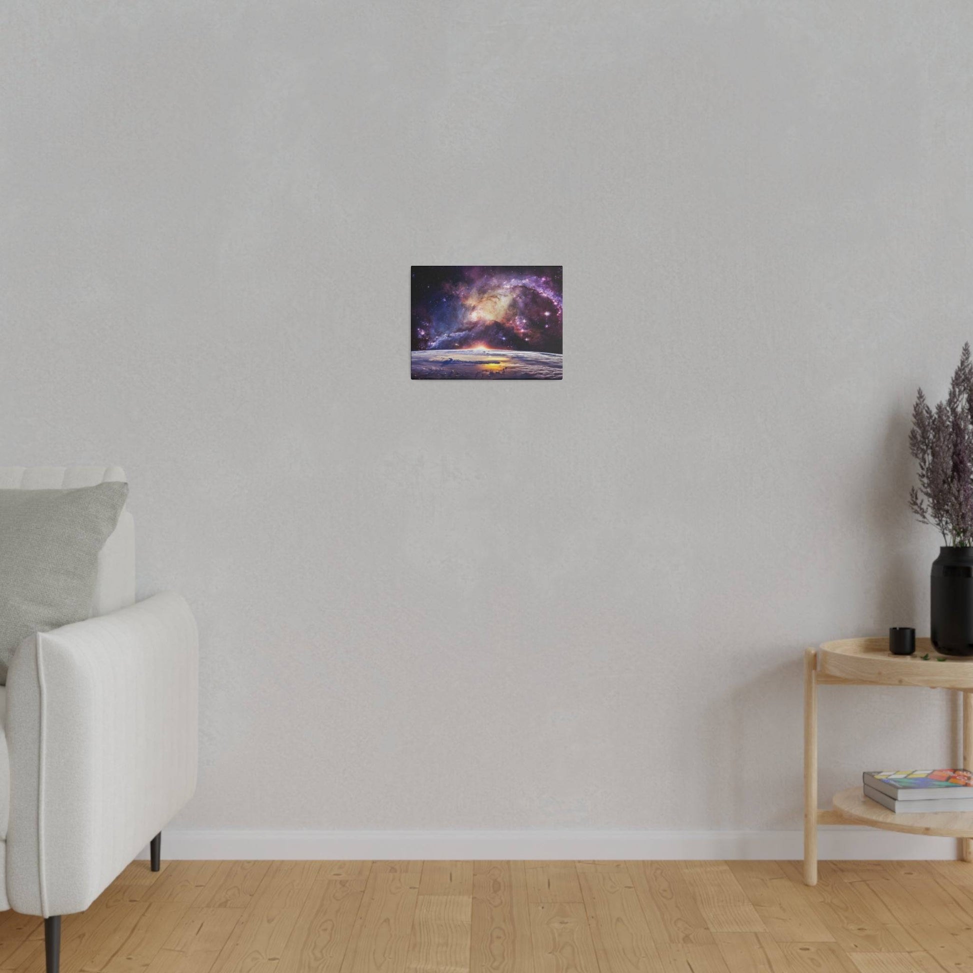 Small rectangular wall art depicting a colorful galaxy over a sunset, hung above a light gray sofa.
