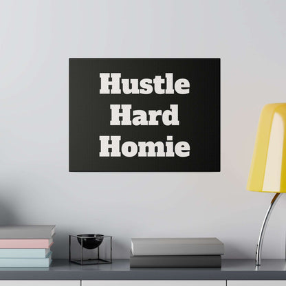 Black square wall sign with large white bold lettering that reads “Hustle Hard Homie”.