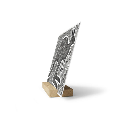 Black-and-white abstract patterned panel leaning on a small rectangular wooden stand.