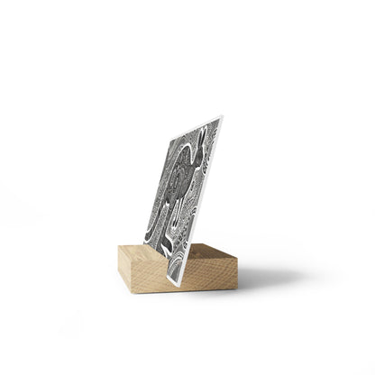 Black-and-white abstract patterned card mounted in a light wooden rectangular stand.
