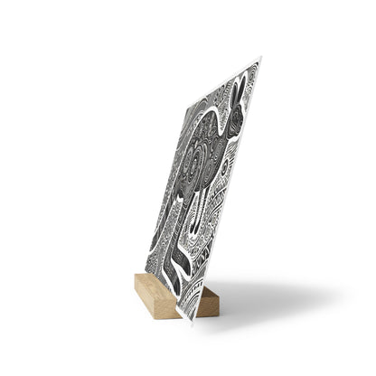 Black-and-white patterned poster on a small wooden easel, tilted upright with intricate swirl designs.