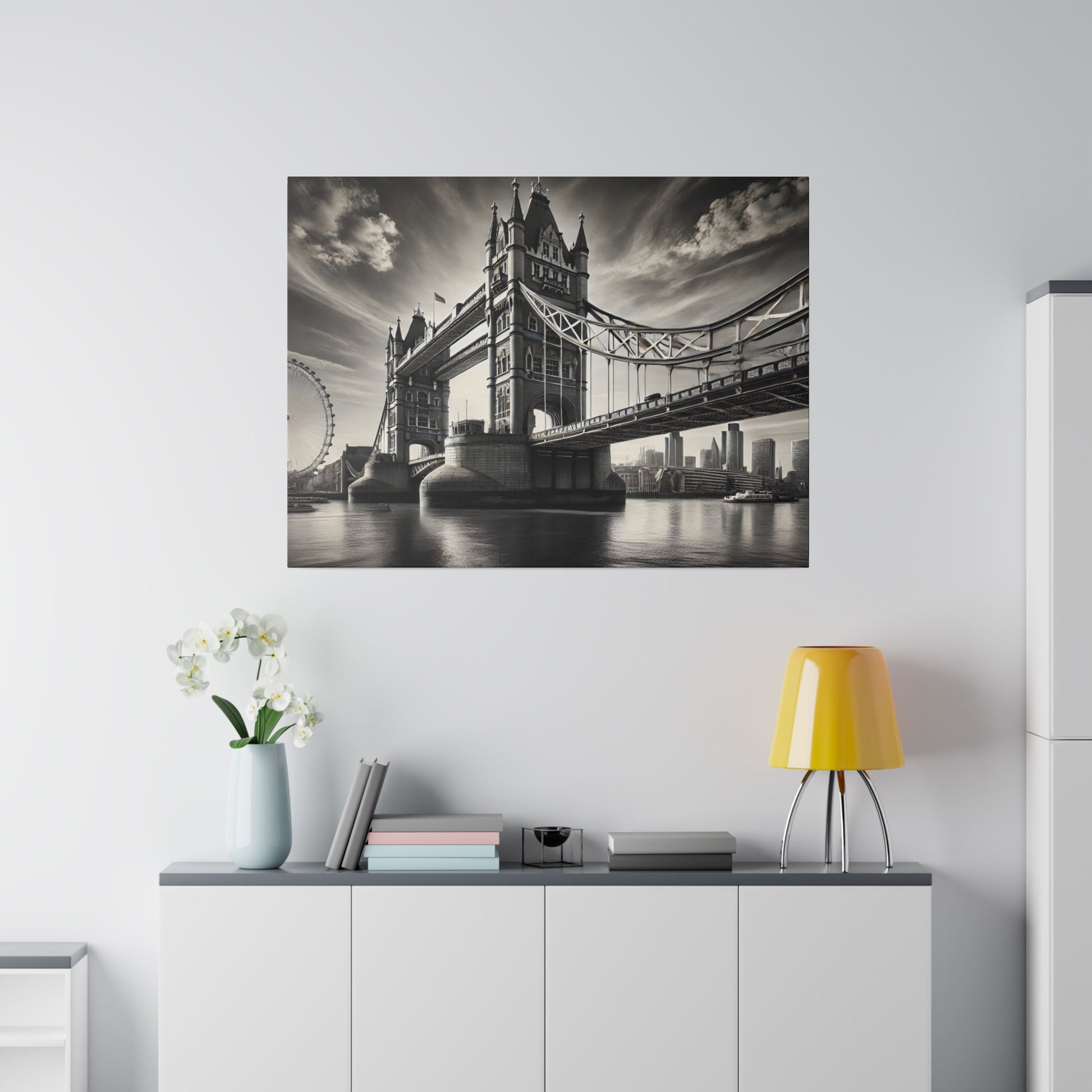 Black-and-white photograph of Tower Bridge spanning the River Thames, hung on a white wall above a console.
