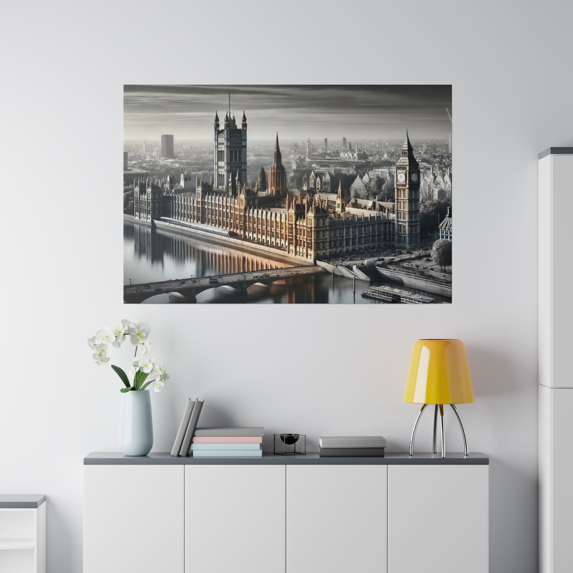 Grayscale image of London's Parliament buildings with Big Ben along the Thames, hung above a white cabinet with a yellow lamp.