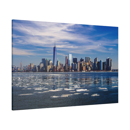 Manhattan skyline across a partially frozen harbor, with blue sky and wispy clouds.