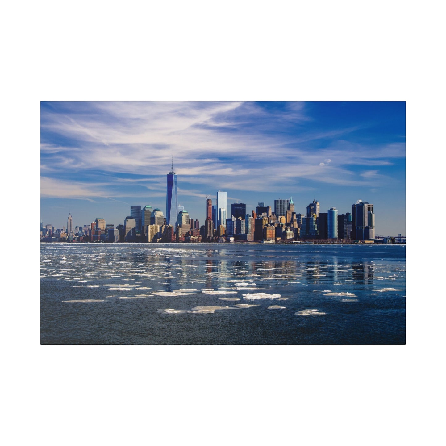 Manhattan skyline seen across an icy river, with clear skies and tall buildings reflecting on the water’s surface.