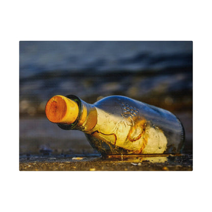 A clear glass bottle with an orange cap lies on a wet, pebbled ground outdoors.