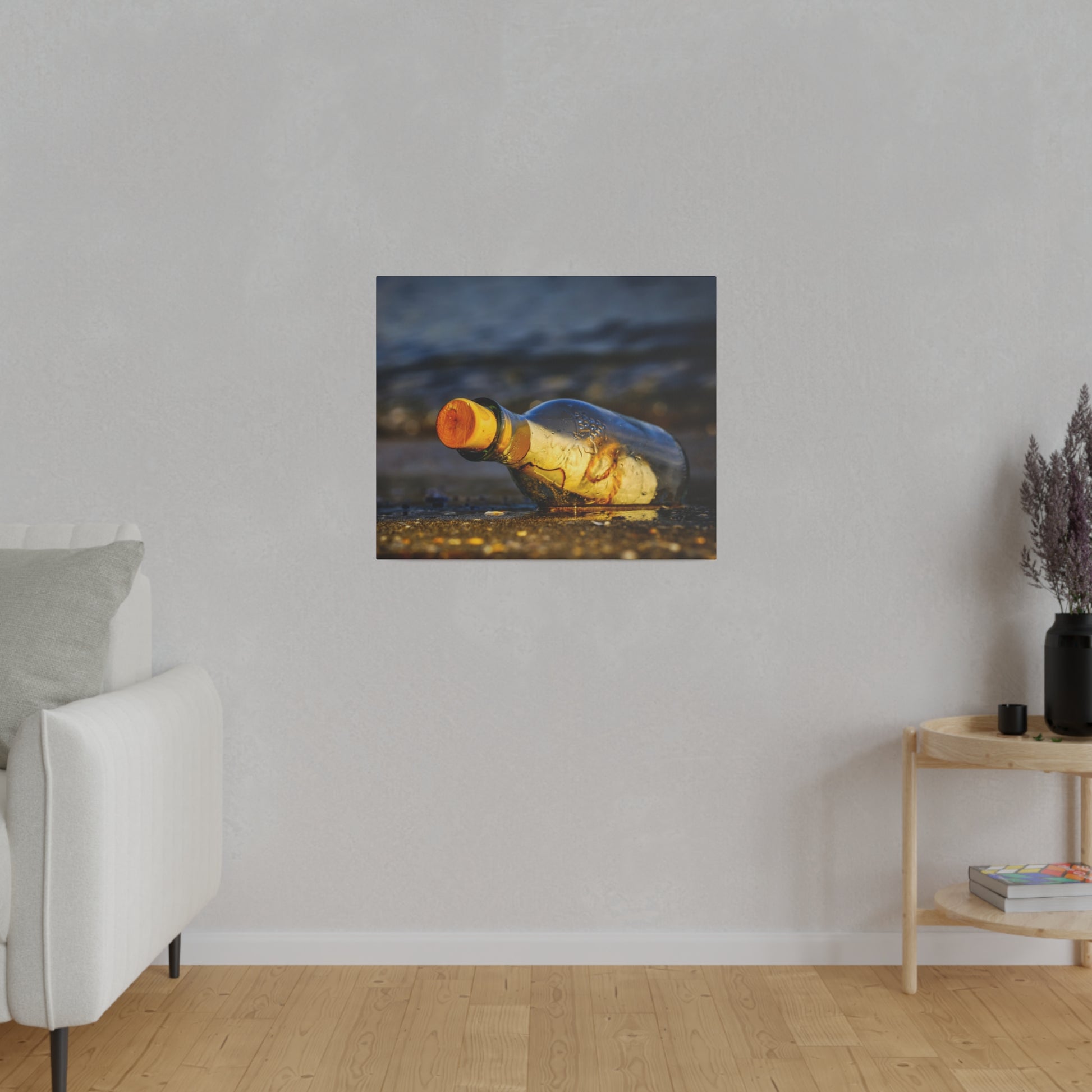 A square wall art print showing an empty glass bottle with an orange cap lying on wet sandy beach.
