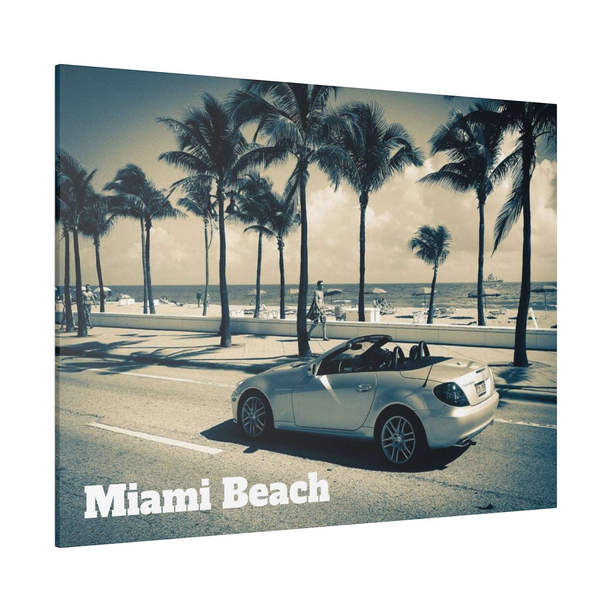 Canvas art print of a silver convertible on a palm-lined Miami Beach road with the ocean in the background.