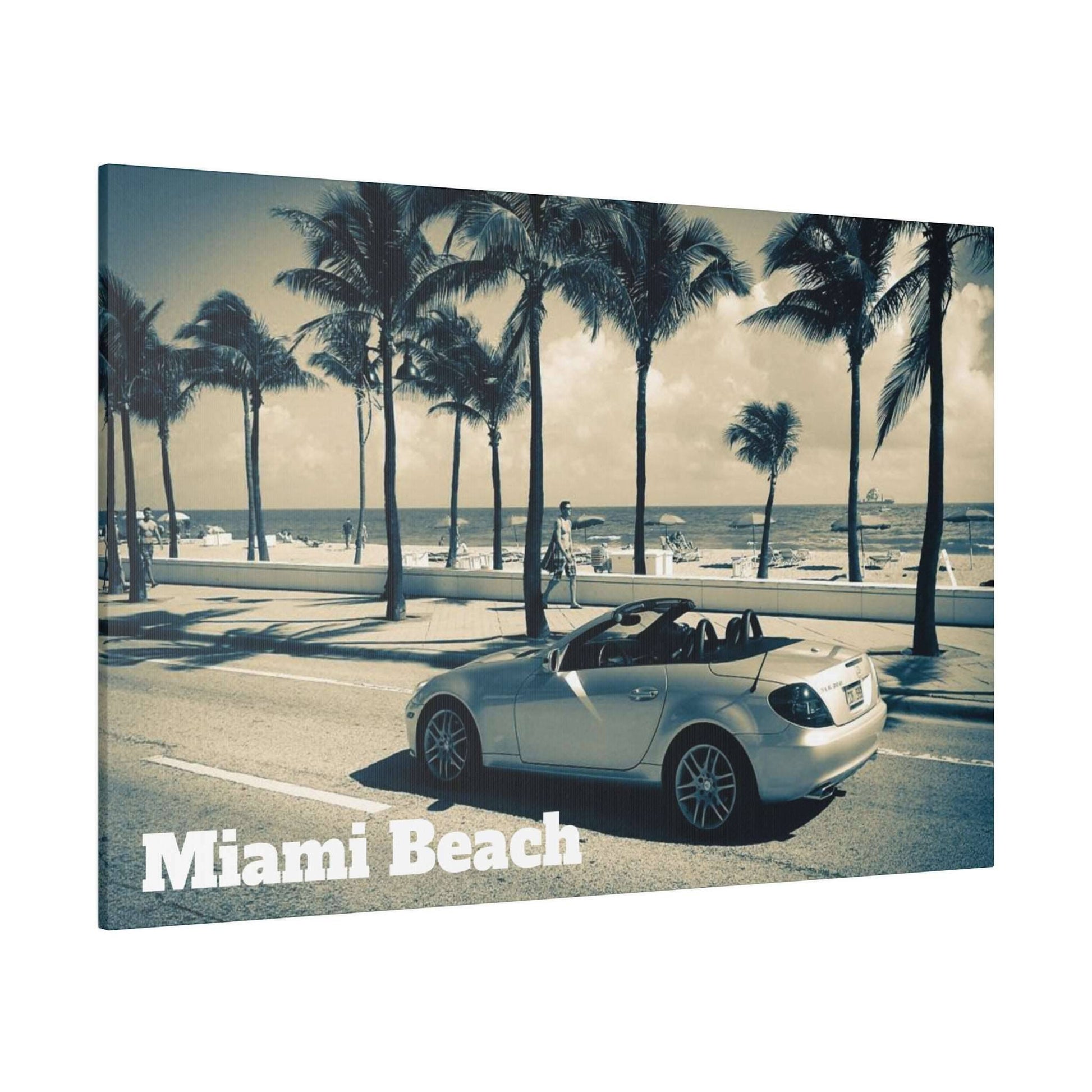 Canvas art showing a silver convertible parked on a palm-tree lined Miami Beach street with the ocean in the background.