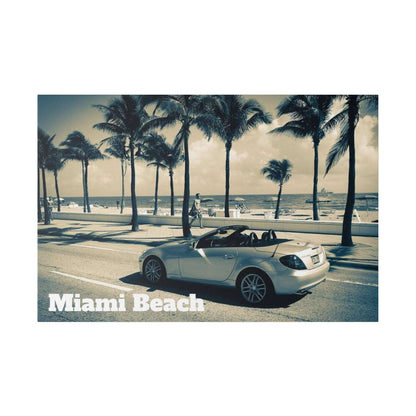 Silver Mercedes-Benz convertible parked on a coastal street with palm trees and the beach in the background.