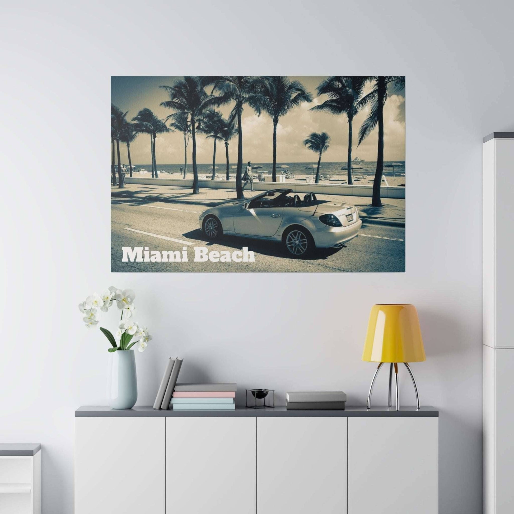 Canvas art depicting a white convertible on a palm-lined Miami Beach street.
