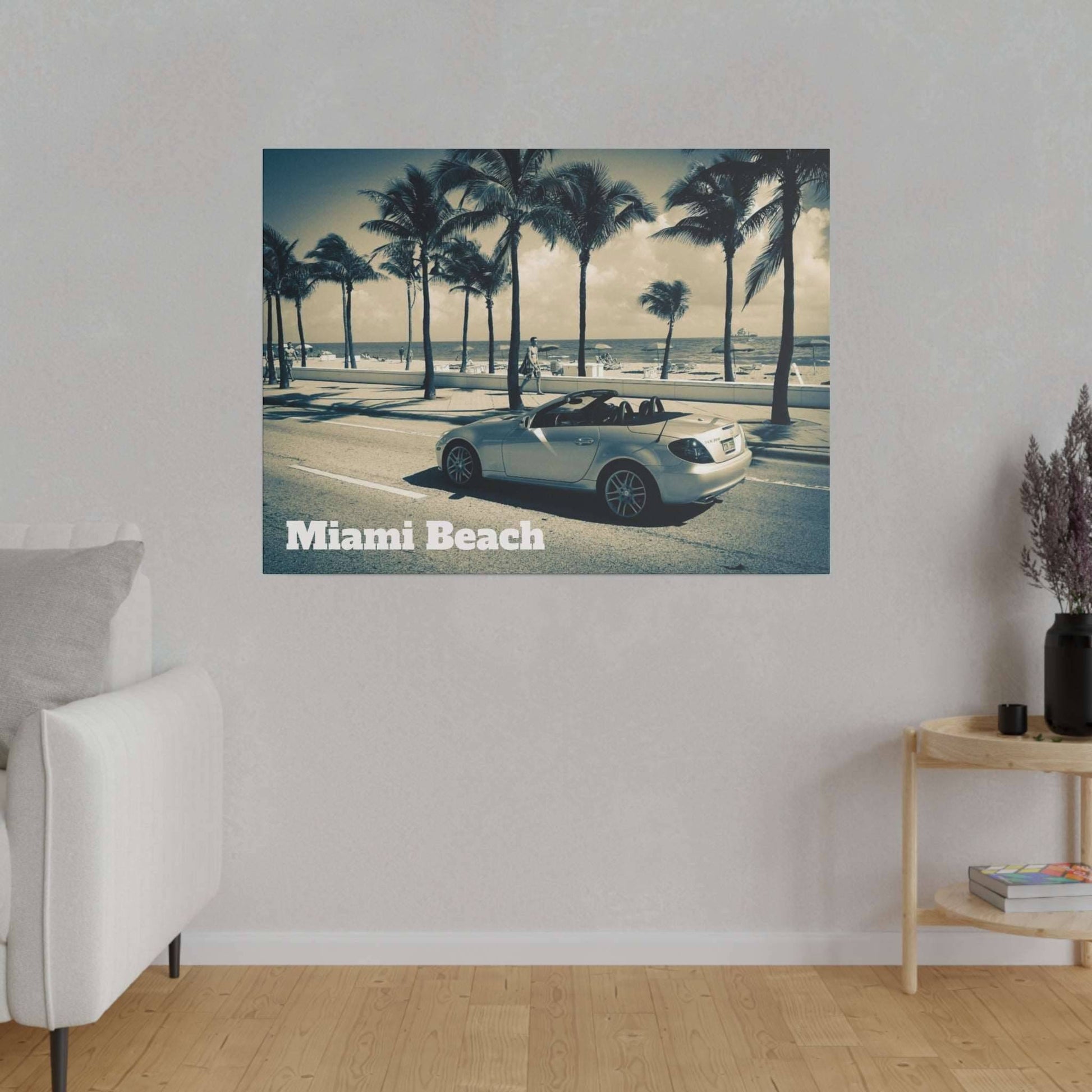 Canvas print of a white convertible on a Miami Beach street with palm trees and the ocean in the background.