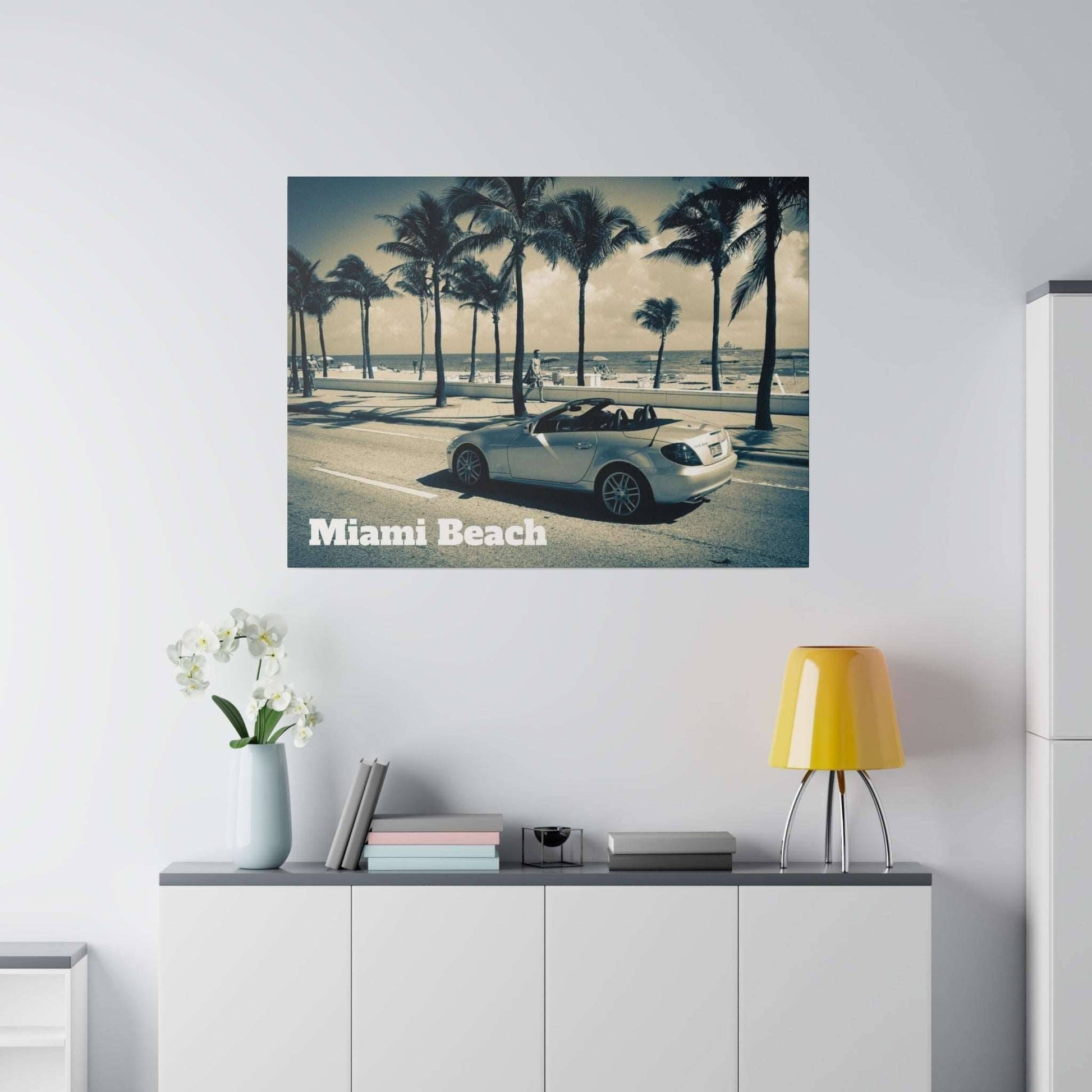 Canvas art depicting a white convertible car parked on a palm-lined Miami Beach street with text 'Miami Beach' in the corner.