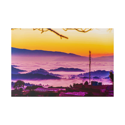 Hilly landscape at sunrise with orange sky, purple fog over layered hills, and a tall antenna among buildings.
