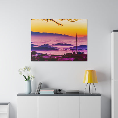 Artwork on the wall showing a sunrise over misty purple hills with a distant town below.