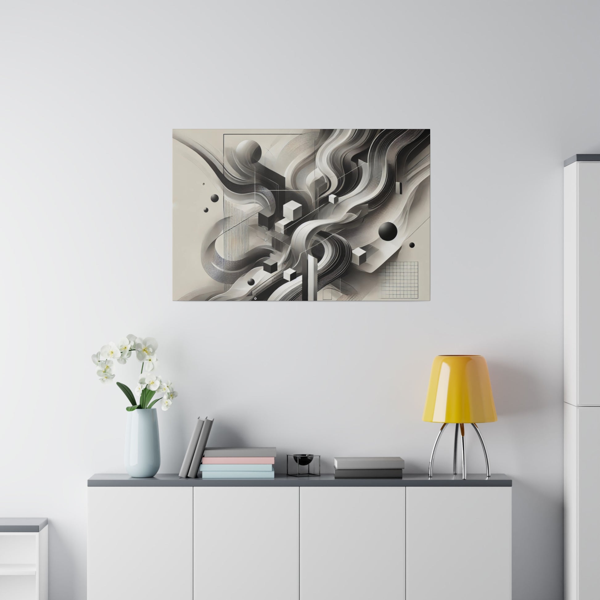 Abstract grayscale wall art above a white cabinet with a yellow lampshade, a light blue vase of white flowers, and stacked books.