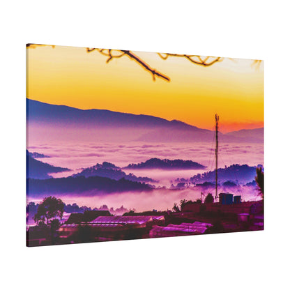 Sunset over a misty valley with purple hills and an orange sky; foreground shows a small village and a tall antenna.