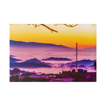 Colorful sunrise over rolling hills with a fog-filled valley, purple and orange sky, and a tall antenna with small buildings in the
