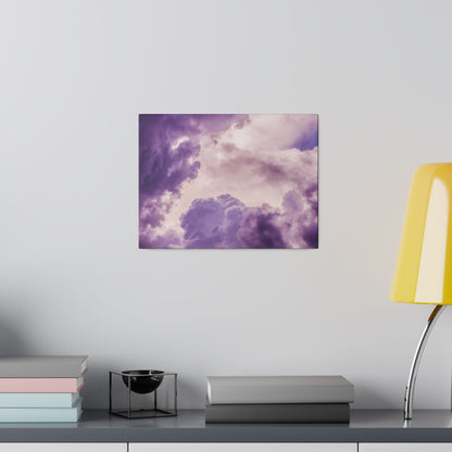 Purple cloud-themed wall art hangs above a shelf with stacked books, a black metal candle holder, and a yellow lamp.