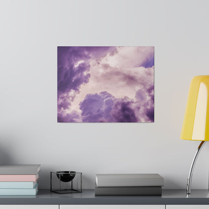 Purple cloud-themed canvas print on a gray wall above a shelf with stacked books, a small black bowl, and a yellow lamp.