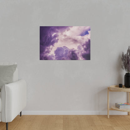 Framed purple cloud artwork hangs on a light gray wall above a wood floor, with a white sofa to the left and a small wooden table to the