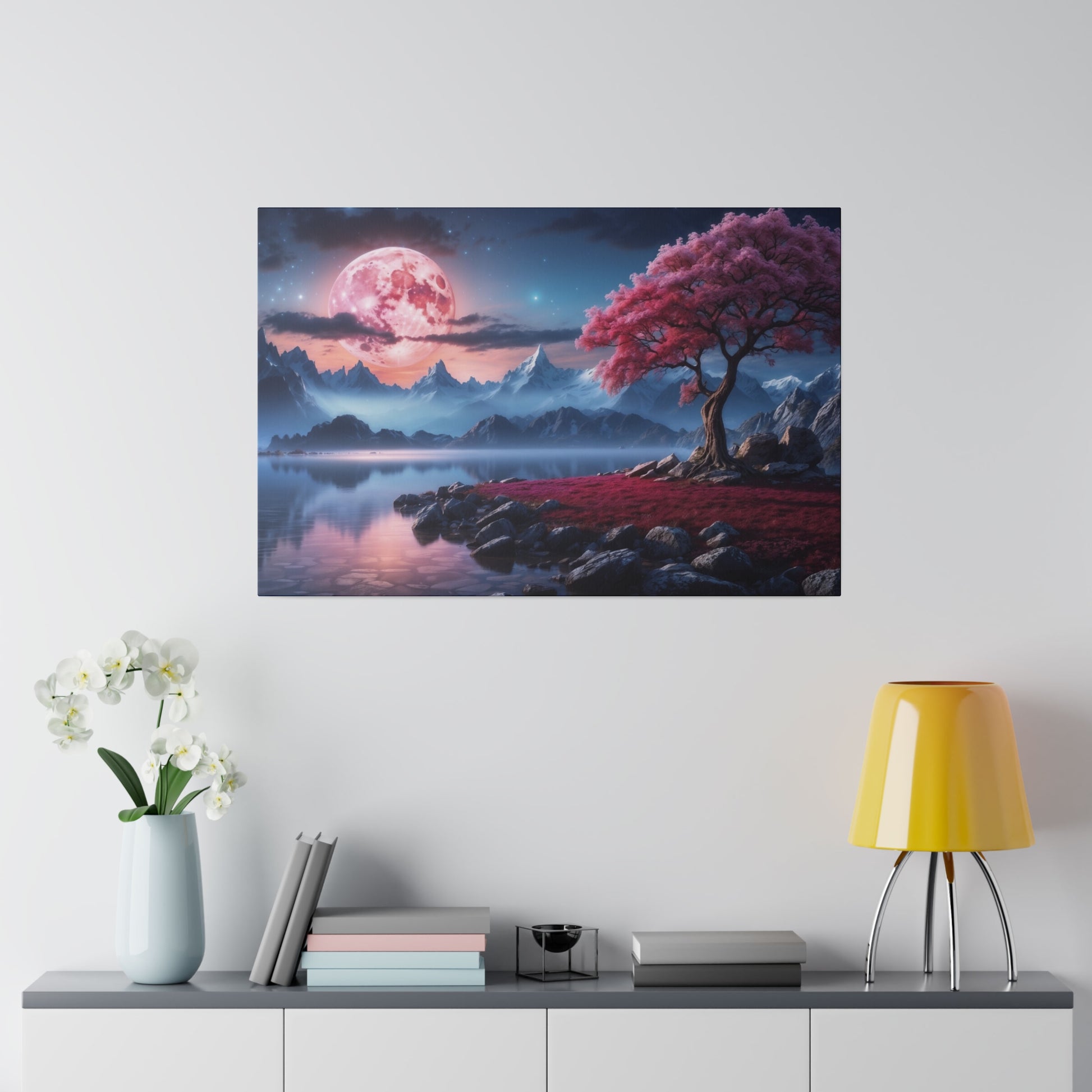 Canvas wall art showing a pink moon over blue mountains, a calm lake, and a pink-leaved tree by rocks.