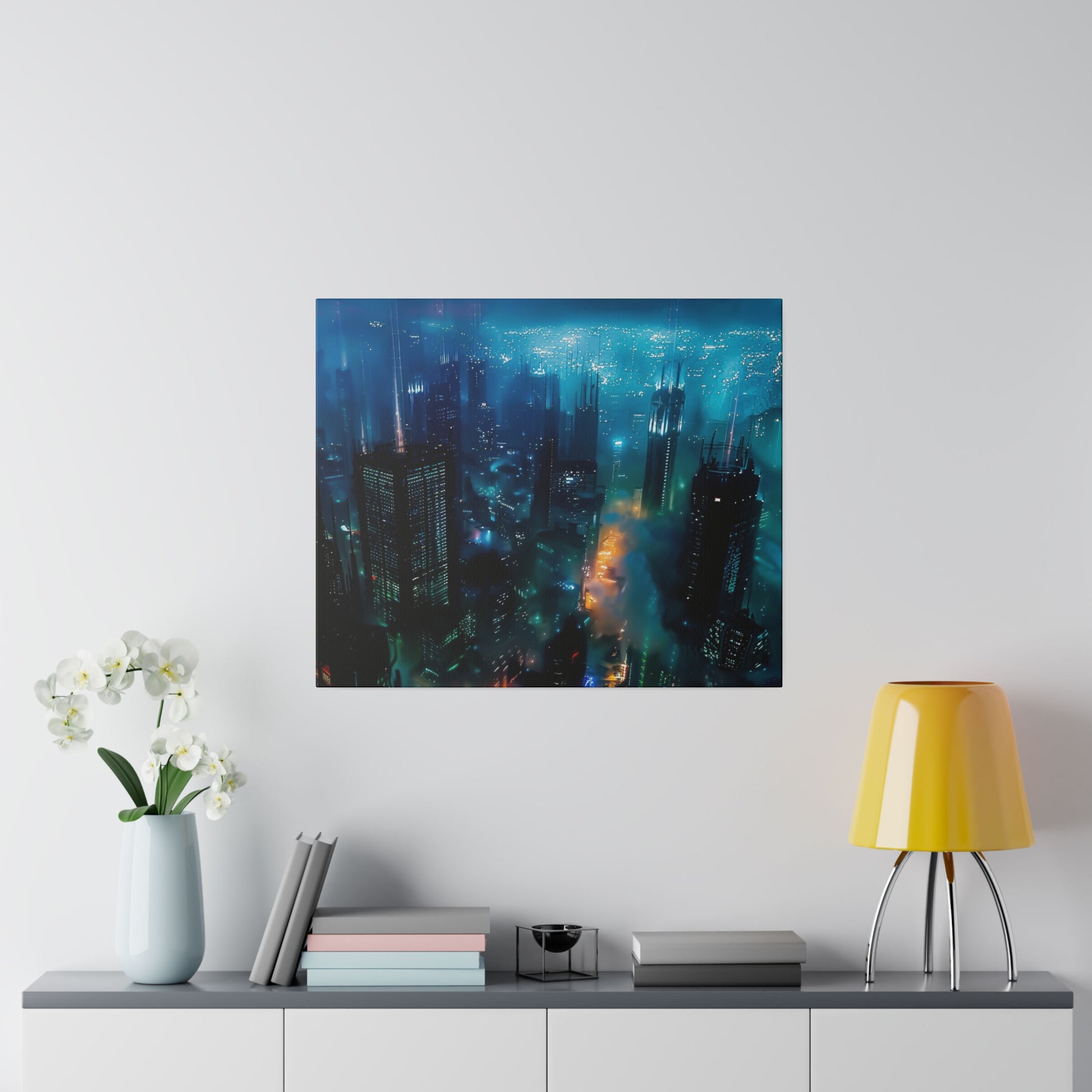 Framed square cityscape print showing a neon-blue night skyline with glowing streets, hanging on a white wall above a console.