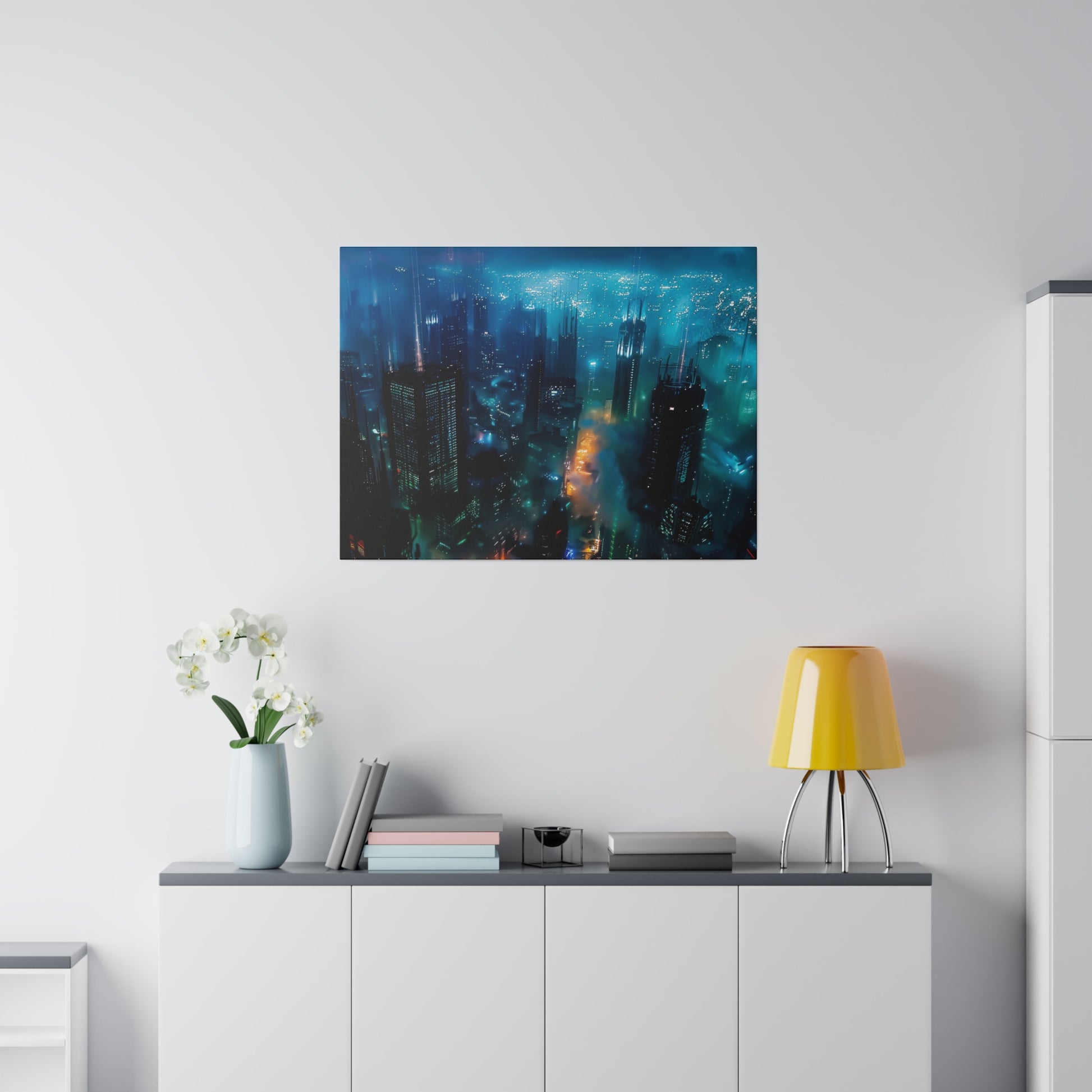 A blue nighttime cityscape artwork hangs above a white sideboard; a yellow lamp, stacked books, and a vase of white orchids sit on the