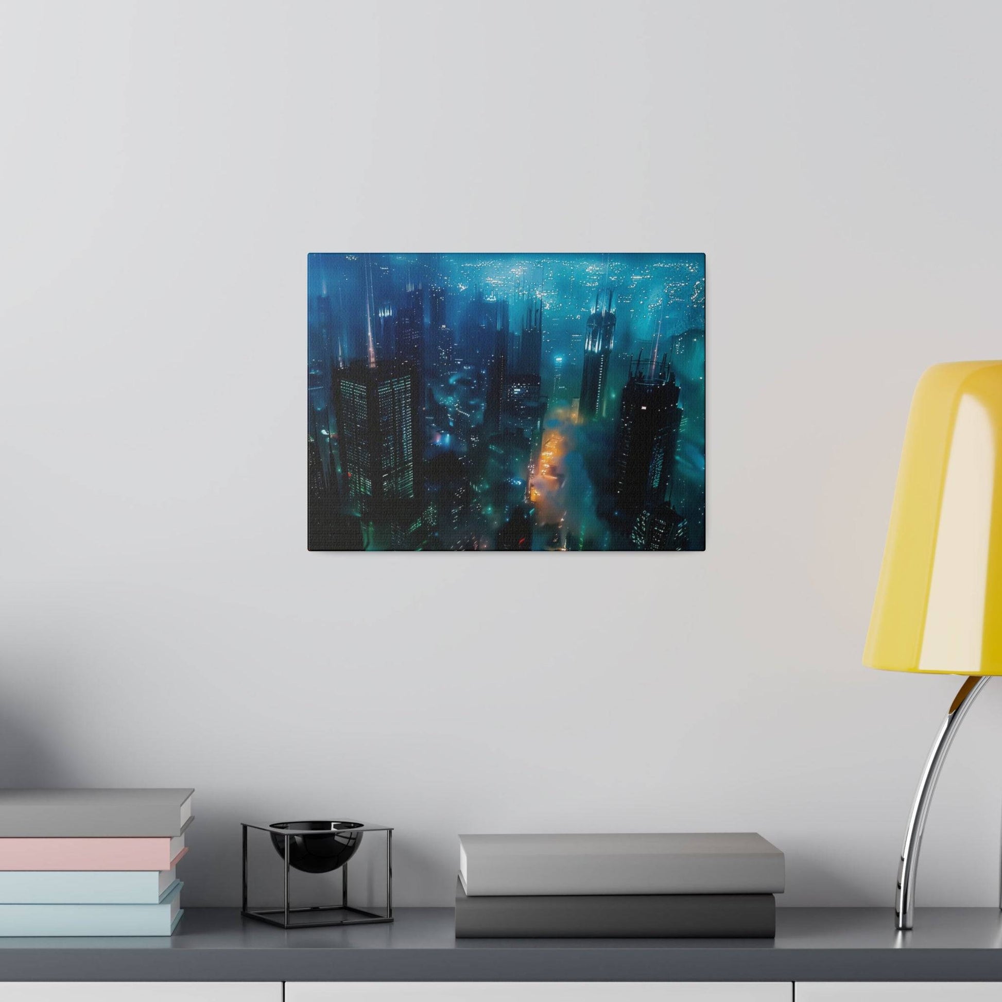Blue urban skyline canvas print mounted on a light gray wall above a desk with stacked books and a yellow lamp.