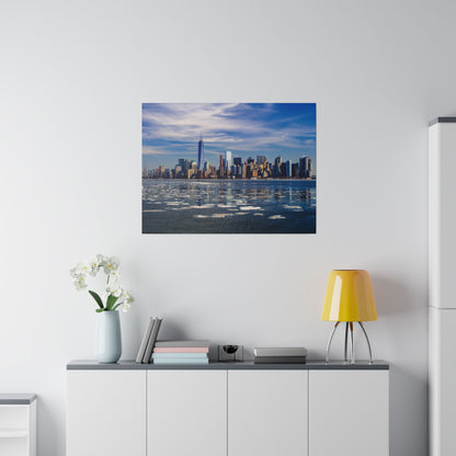 Framed photo of the New York City skyline across a partially frozen river, hung above a white cabinet.