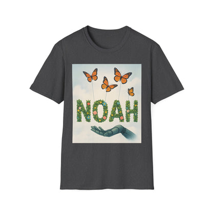 Dark gray t-shirt featuring the word NOAH formed from green leaves and flowers, with orange butterflies above and a blue hand beneath.