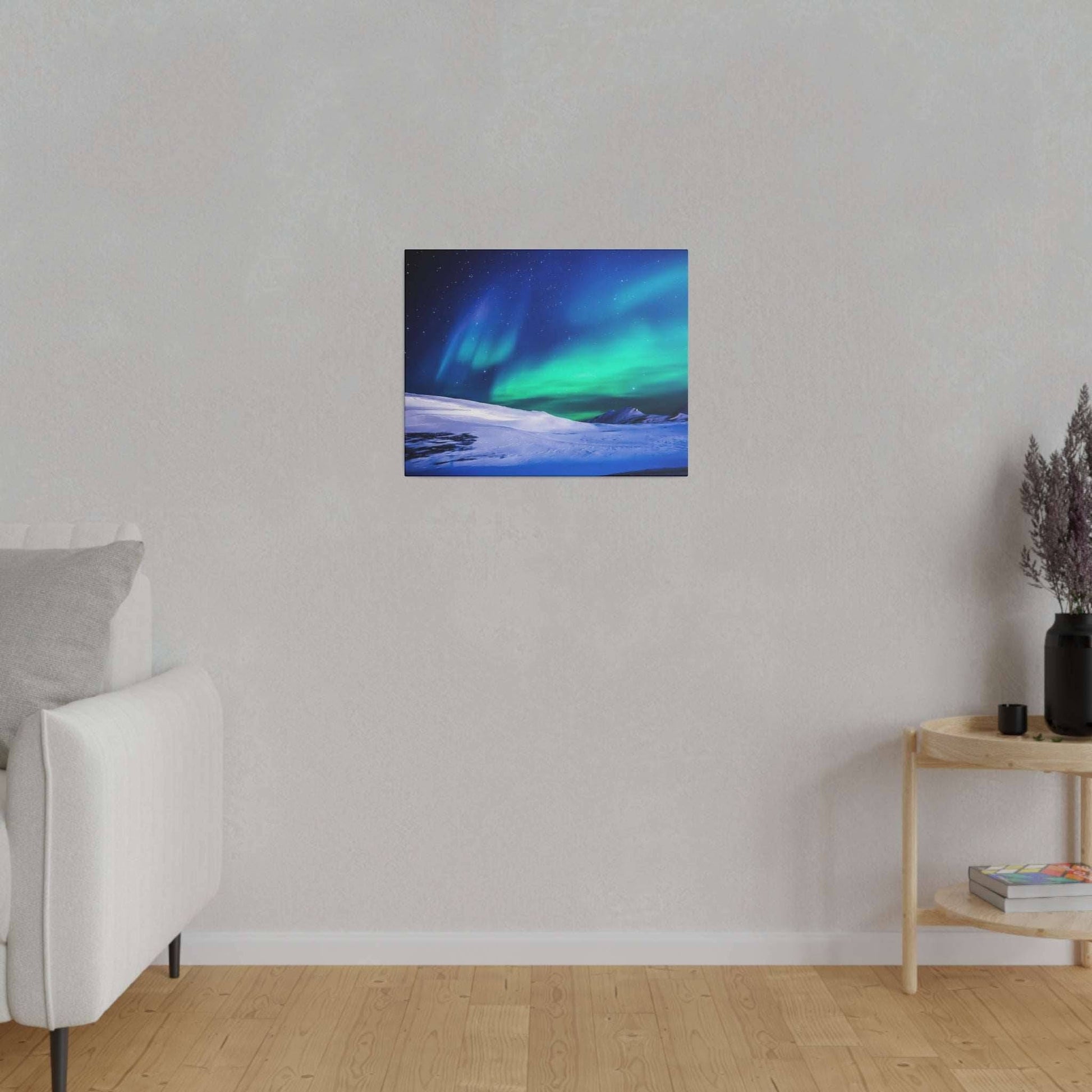 Small square canvas print of the Northern Lights over a snow-covered landscape, hung on a light gray living-room wall.