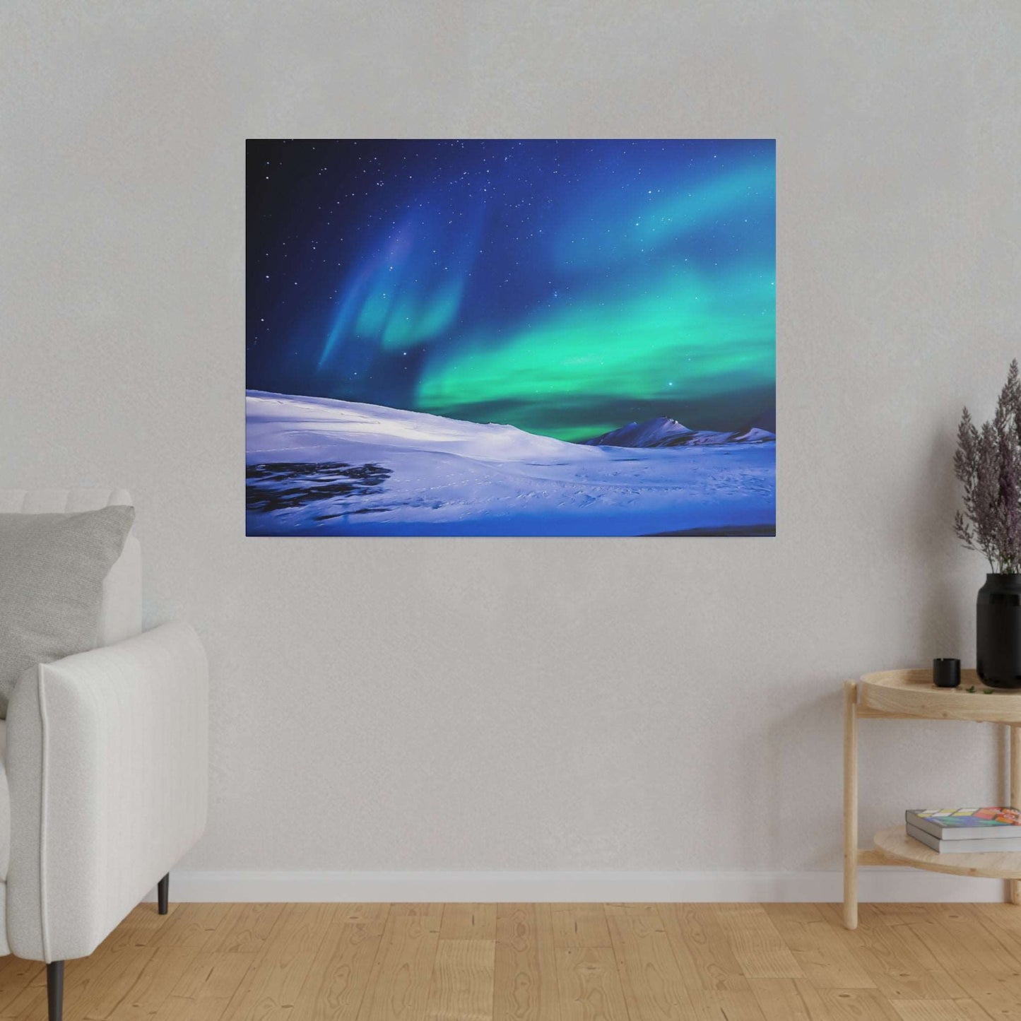 Square canvas on a neutral wall showing a snowy landscape beneath green and blue northern lights.