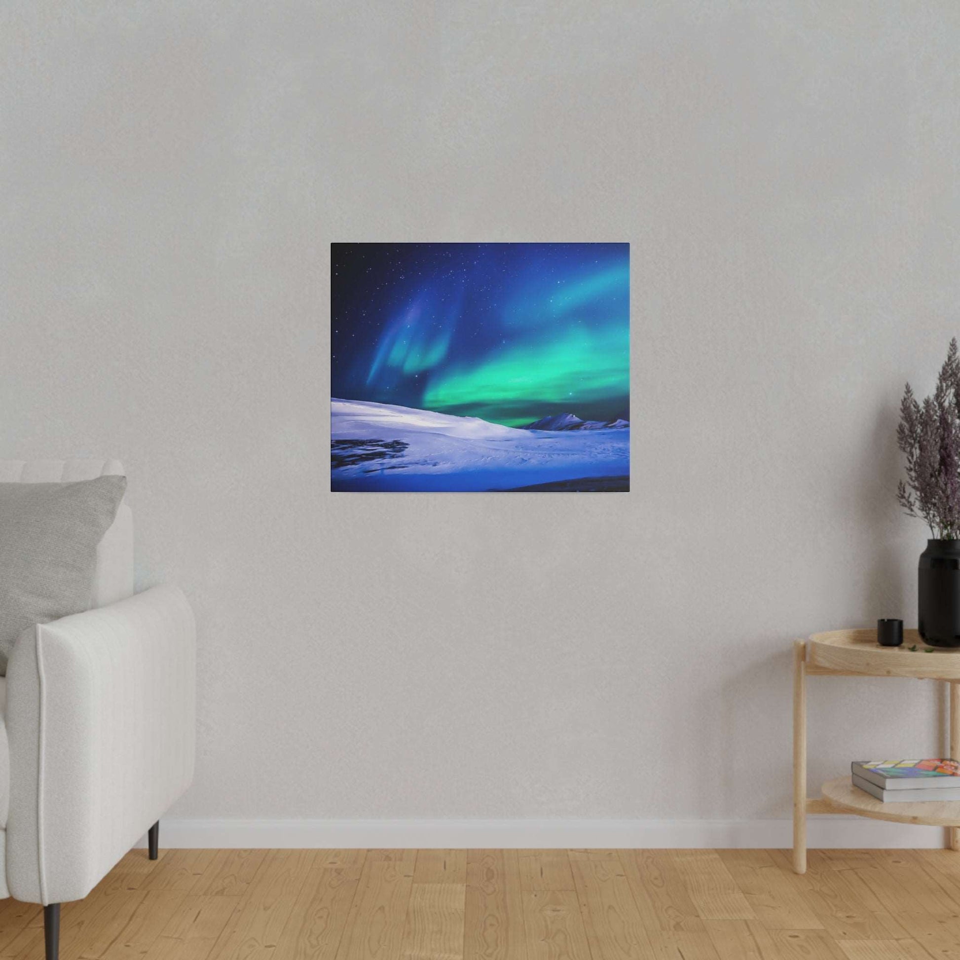 Square canvas print of green and blue Northern Lights over a snow-covered landscape, hung on a light gray wall.
