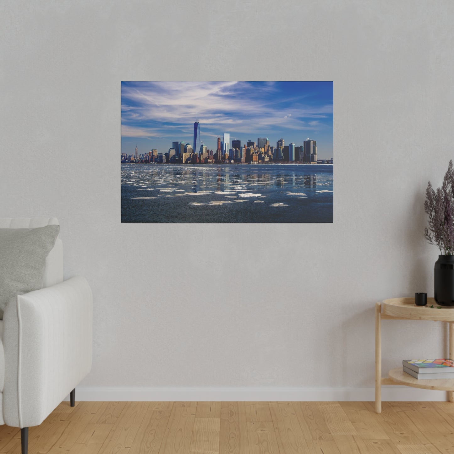 Waterfront view of the New York City skyline, with the serene river and ice patches complementing the cityscape.