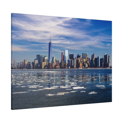 New York City skyline across a partially frozen harbor, with scattered ice floes on dark blue water.