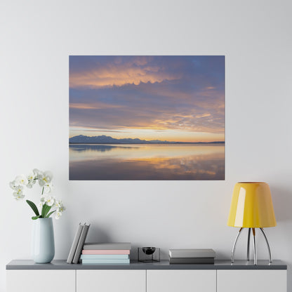 Square canvas print depicting a calm lake at sunset with orange–purple skies and a mountain silhouette reflected on the water.