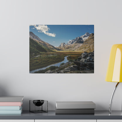 Framed landscape photo of a mountain valley with a winding river, rocky foreground, and blue sky.