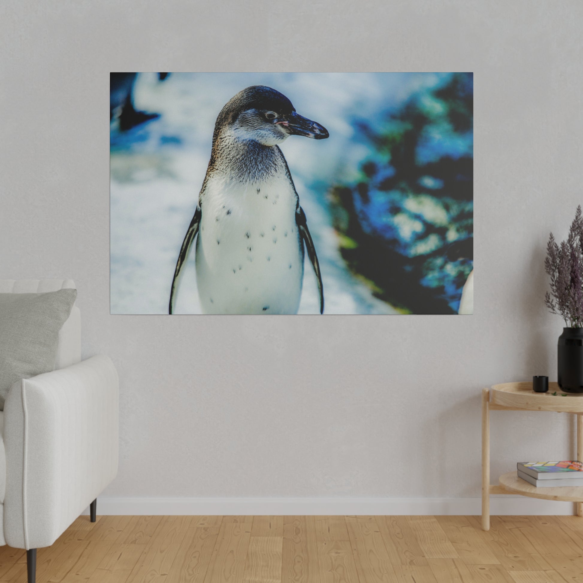 A penguin on snowy terrain, with a blue and white blurred background. The image captures the penguin in its cold, natural habitat.