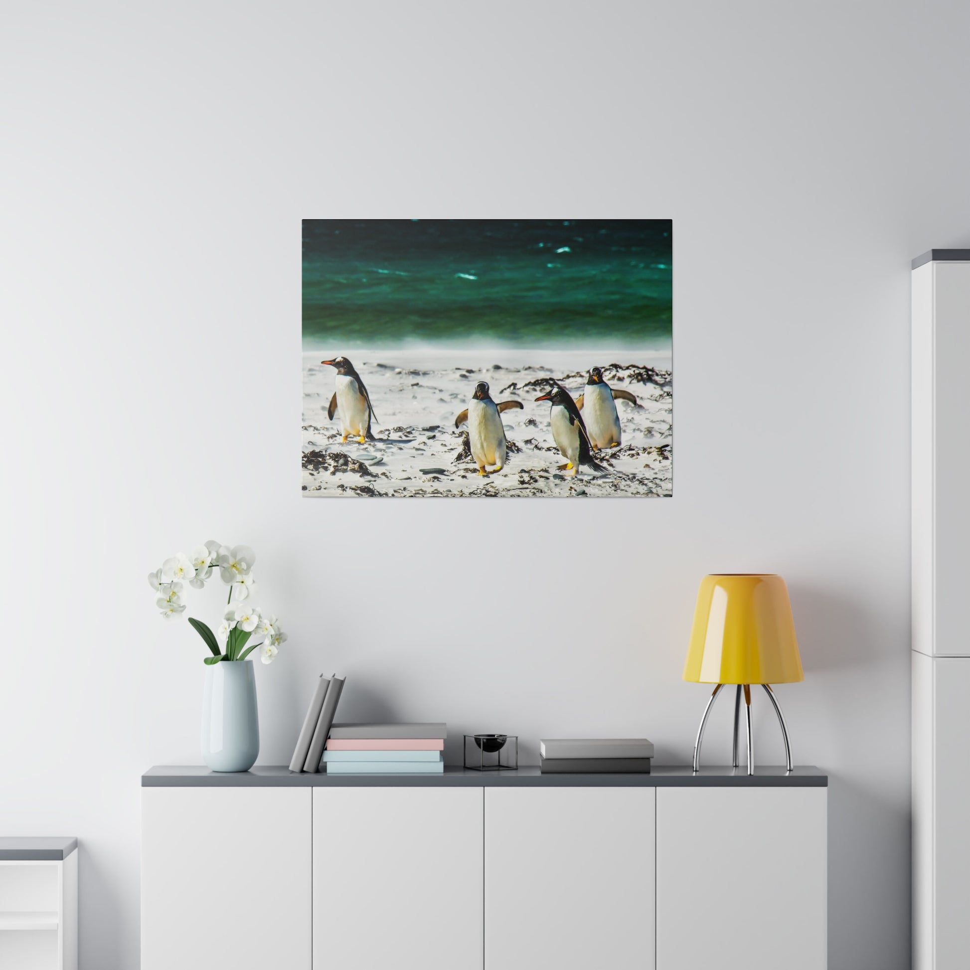 Penguins strolling along a beach, with the vibrant green-blue ocean in the background. The scene captures the natural beauty of these seabirds in their habitat.