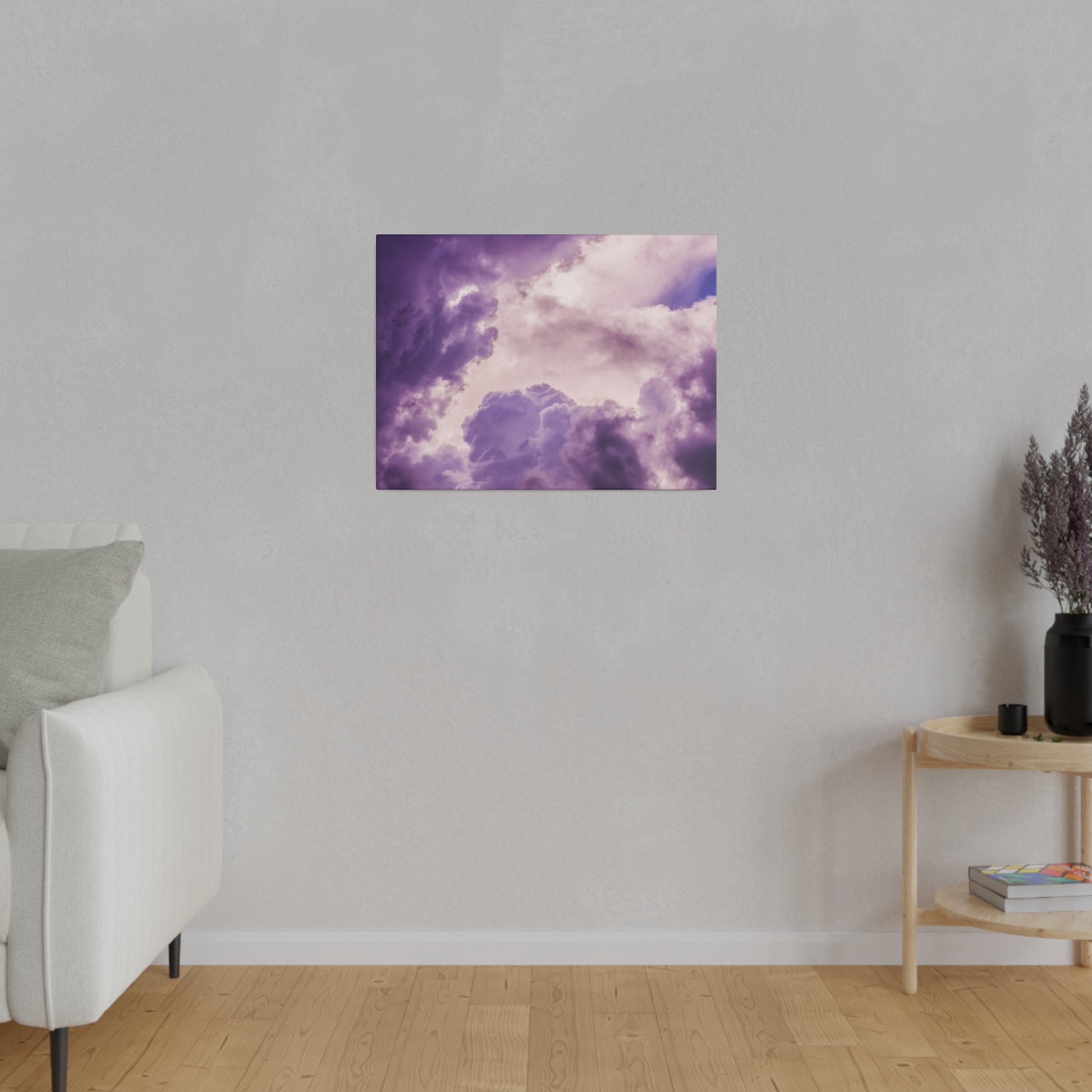 Small square art print of purple and pink cloudy sky hung on a gray wall in a living room.