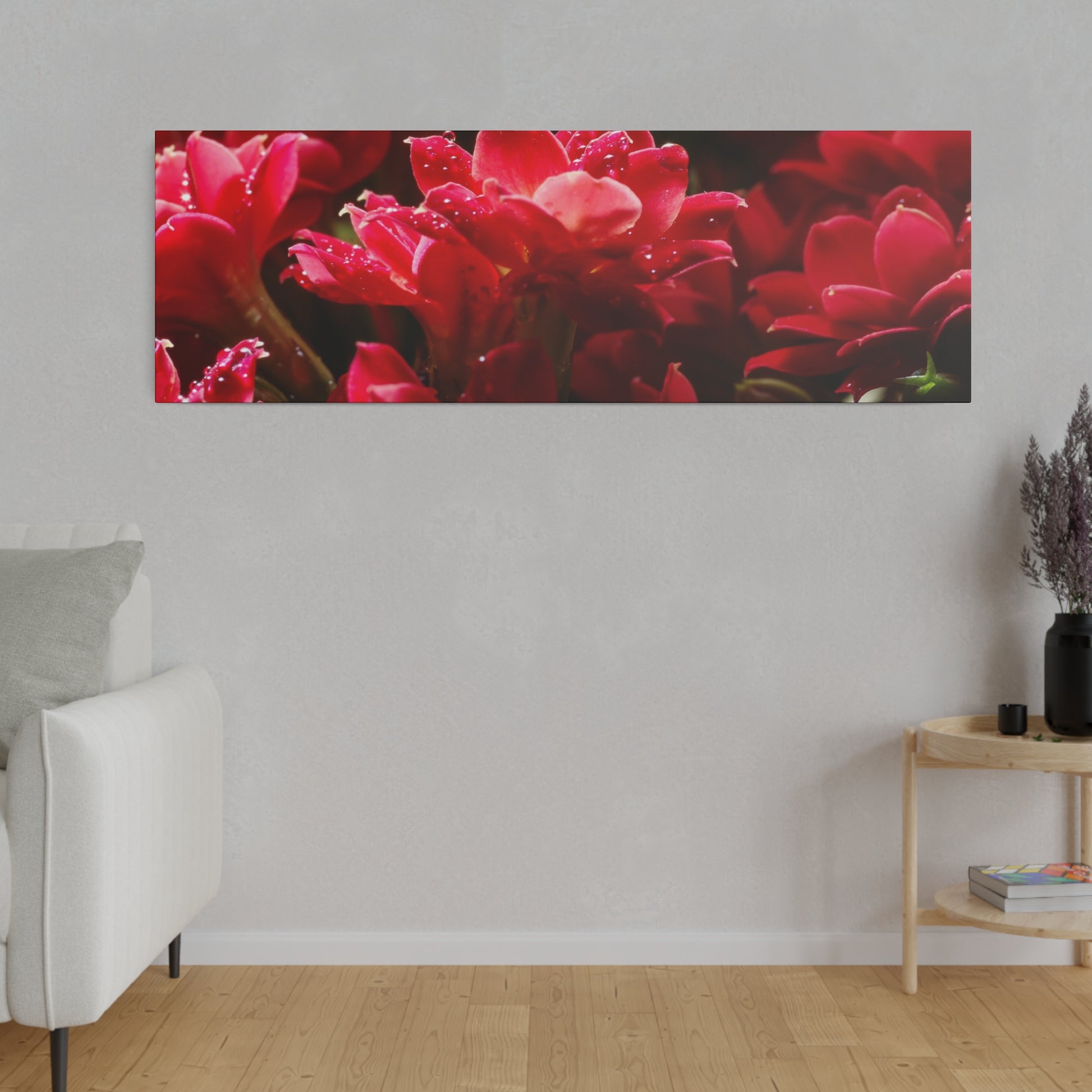 Rectangular wall art print of vivid red flowers with dewdrops, mounted on a light gray wall.