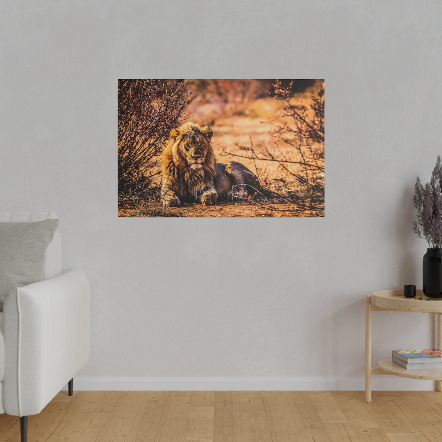 A lion resting among dry bushes in the savannah, bathed in warm sunlight. The lion's impressive mane and intense gaze reflect its natural strength.