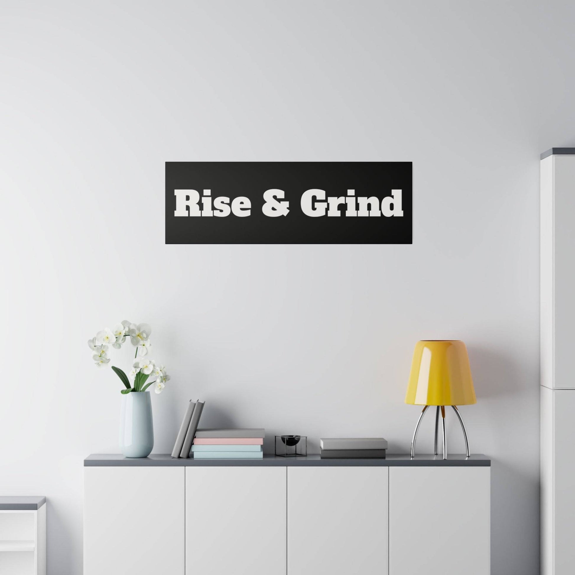 White cabinet against a light wall with a yellow lamp and a black sign reading "Rise & Grind.